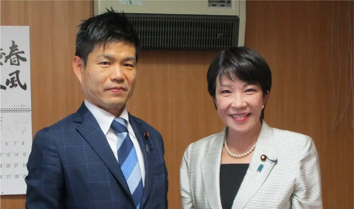 スーツ姿で記念撮影をする、政調会長の高市早苗先生とかつまた孝明